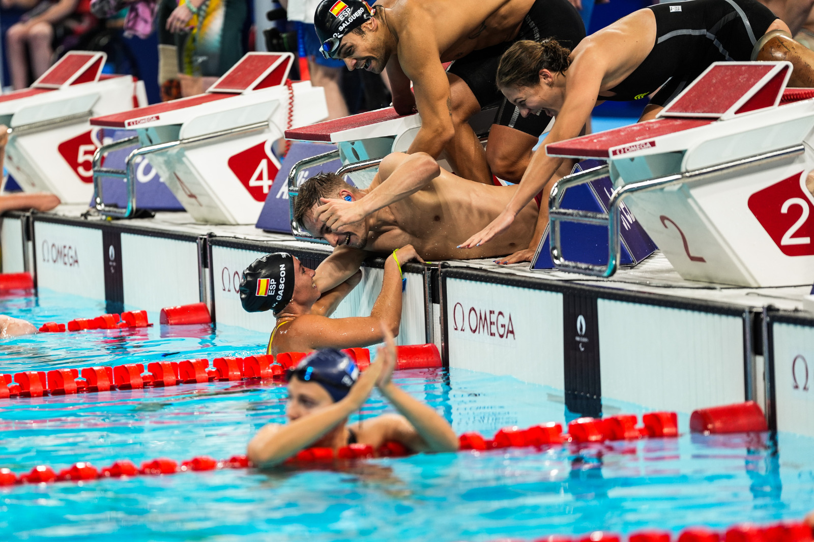 Núria Marquès, Óscar Salguero e Íñigo Llopis festejan el bronce del relevo 4x100 estilos mixto con Sarai Gascón en el agua. Foto: CPE